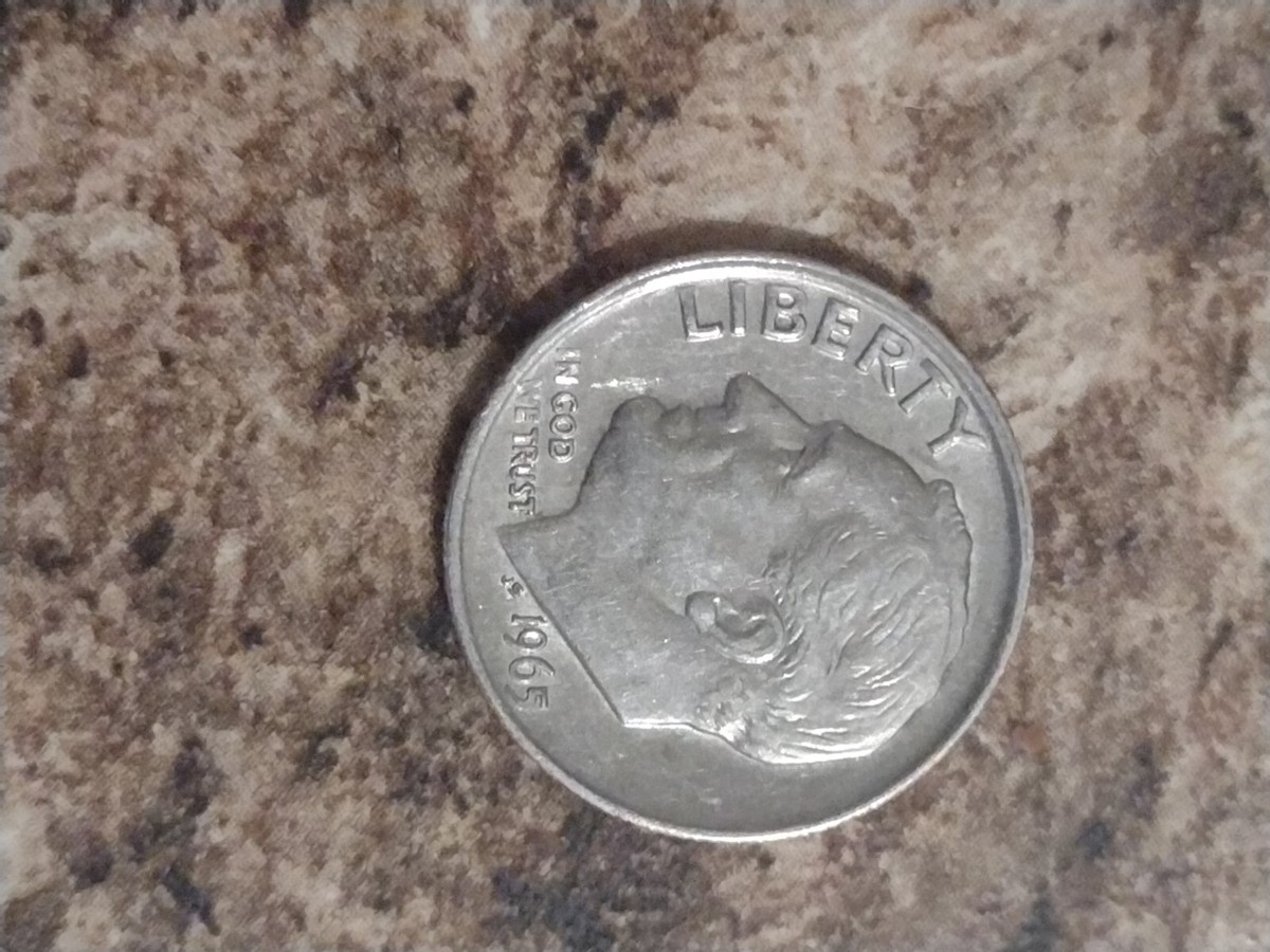 1965 dime off-center strike error showing partial Roosevelt portrait with blank crescent area on planchet
