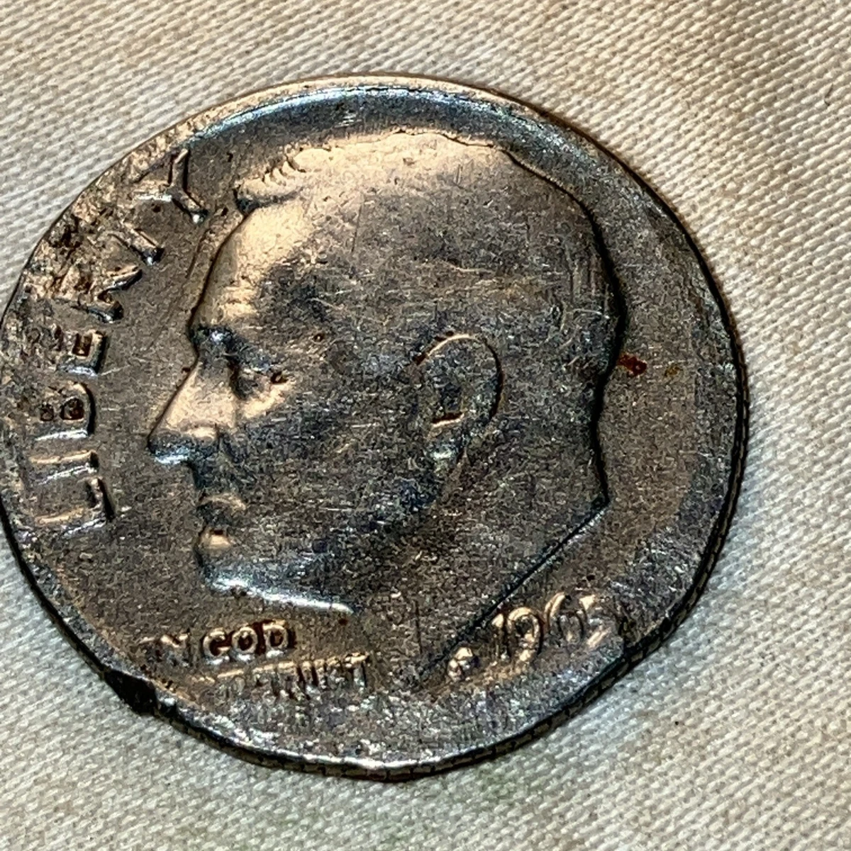 1965 dime die crack error showing raised line across Roosevelt portrait, detail under magnification